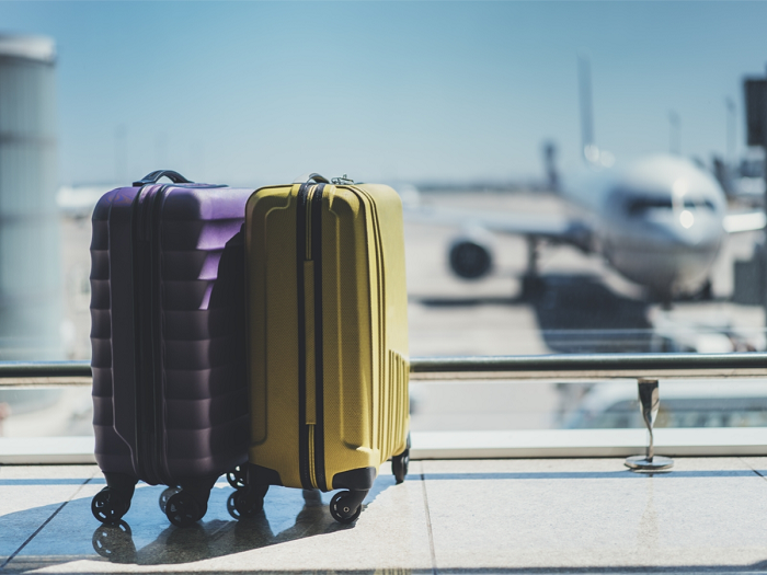 Ett par resväskor och ett flygplan i bakgrunden, fotografi